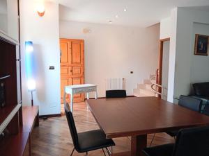 a living room with a wooden table and chairs at casa mare bellissima in Alghero