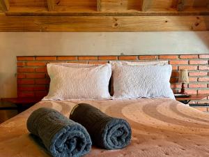 a bed with two large pillows on top of it at Chalé com Hidromassagem em Garopaba in Palhocinha +6 photos