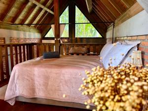 a bedroom with a bed and a large window at Chalé com Hidromassagem em Garopaba in Palhocinha
