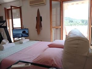 a bedroom with a large bed and a tv at casa mare bellissima in Alghero