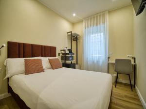 Un dormitorio con una gran cama blanca y una silla. en Gioia Guest House, en Ciampino