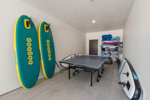 een kamer met een pingpongtafel en surfplanken bij Ivory Shores condo in Atkinville
