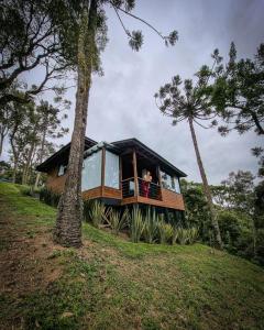 a woman is looking out of the window of a house at Vale Dourado Cabanas in Urubici