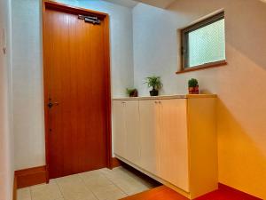 a hallway with a door and a cabinet with plants on it at 4-5F Ikebukuro Business District hotel, 9 mins to ST Max 4P 池袋商务区 全新装修 交通中心 车站9分钟 最大4人 直达新宿 涉谷 表参道 品川 池袋 上野 代代木 银座 原宿 in Wada