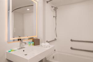 a white bathroom with a sink and a mirror at B&B HOTEL Orlando International Drive near Universal - Newly Renovated! in Orlando +19 photos