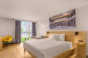 a hotel room with a bed and a yellow chair at B&B HOTEL Orlando International Drive near Universal - Newly Renovated! in Orlando