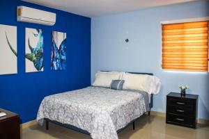 una camera da letto con un letto e una parete blu di Terry's House a Cozumel