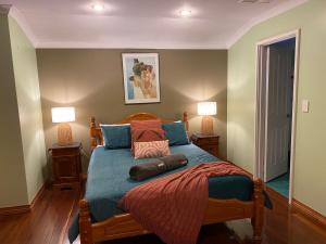 a bedroom with a large bed with two lamps at Cheerful Sunny Garden Close Fremantle Netflix Wine in Hamilton Hill