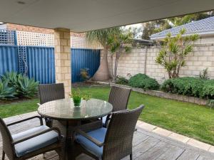 a patio with a table and chairs and a yard at Cheerful Sunny Garden Close Fremantle Netflix Wine in Hamilton Hill