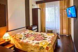a bedroom with a bed with a flowered blanket at Санаторій Кришталевий Палац 4 корпус in Truskavets
