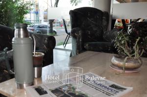 a table with a water bottle and a chair on it at Hotel Bulevar in Paysandú