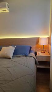 a bedroom with a bed with a nightstand and a lamp at Apartamento Descolado Zona Norte in Boa Vista