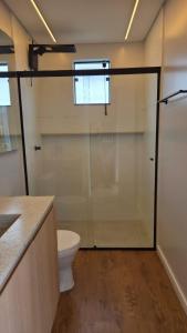 a bathroom with a toilet and a glass shower stall at Apartamento Descolado Zona Norte in Boa Vista