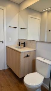 a bathroom with a white toilet and a sink at Apartamento Descolado Zona Norte in Boa Vista