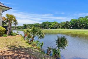 a pond with palm trees next to a house at TP4937: 4937 Turtle Point in Kiawah Island