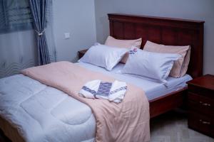 a bed with two pillows on top of it at Creation Homes Uganda in Tororo