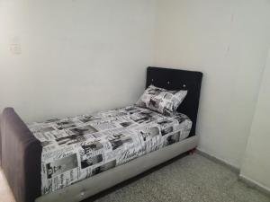 a bedroom with a bed with a newspapercovered bedspread at KASBAH Guests Travel in Fès