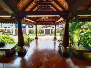 eine überdachte Terrasse mit Bänken und Palmen in der Unterkunft Azza by Travelista in Kochi