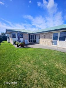 a building with a lawn in front of it at The Holiday Haven in Tauranga
