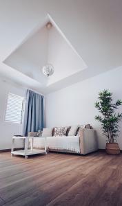 un soggiorno bianco con divano e pianta di Casa Min26 a Caleta De Fuste Altre 19 foto