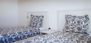 two beds with blue and white covers in a bedroom at Casa Min26 in Caleta De Fuste