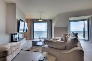 シーハウシズにあるWater's Edge at Farne House, Seahousesのソファがあり海が見えるリビングルーム