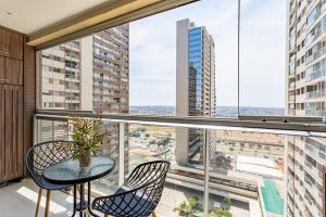 a balcony with a table and chairs and a large window at TOP 10 apartamento dentro do shopping in Brasilia