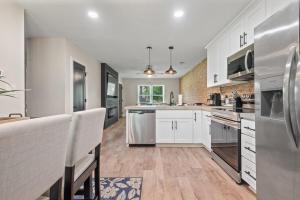 a kitchen with white cabinets and stainless steel appliances at Modern 2 Bedroom Home with Fire Pit, Bikes in Portsmouth