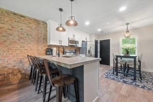 a kitchen with a brick wall and a counter with chairs at Modern 2 Bedroom Home with Fire Pit, Bikes in Portsmouth +7 photos