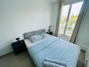 a bedroom with a bed and a large window at Appart Lumineux et Cozy à 25 min de Paris in Boissy-Saint-Léger