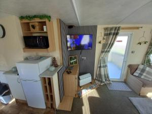 a small kitchen with a refrigerator and a sliding door at SANDY BAY STAYOVER in North Seaton