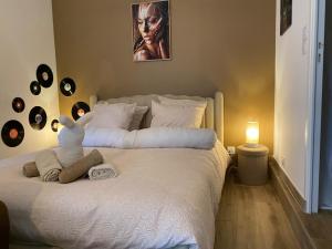a bedroom with a white bed with a teddy bear on it at Studio Cosy dans les granges d un château accès spa in Varennes Vauzelles +44 photos