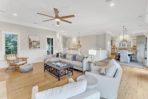 Una sala de estar con muebles blancos y un ventilador de techo. en CM3008: 3008 Cameron Blvd., en Isle of Palms