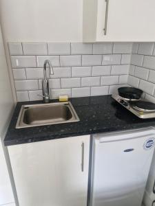 a kitchen with a sink and a counter top at Apartment Harrow Wealdstone in Hatch End