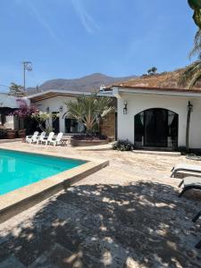 a villa with a swimming pool and a house at Villa Convivencia in San Juan Cosalá