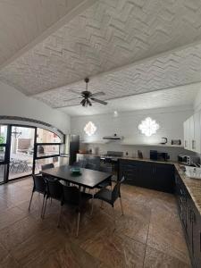 a kitchen with a dining table and a ceiling fan at Villa Convivencia in San Juan Cosalá +34 photos
