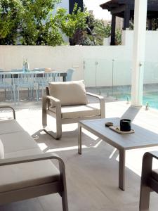 a patio with chairs and a table and a coffee table at וילת Velizabeth in Omen