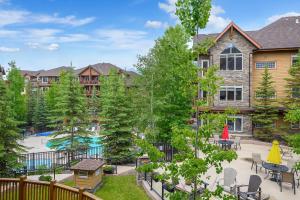 an apartment patio with a pool and tables and chairs at Stoneridge Mountain Resort Condo managed by Little Sister Getaways in Canmore