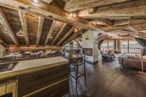 an open kitchen and living room with wooden ceilings at Chalet Rte Brigues Courchevel in Courchevel