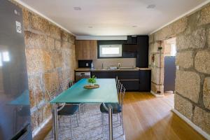 a kitchen and dining room with a blue table and chairs at Casa da Boavista in Amarante