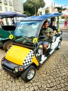 un grupo de personas montando en un pequeño coche en Totally Tour Portugal LDA, en Lisboa