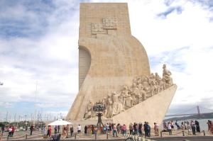 Un grupo de personas de pie alrededor de un monumento. en Totally Tour Portugal LDA, en Lisboa