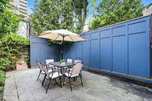 une table et des chaises avec un parasol sur une terrasse dans l'établissement Family-Friendly Modern 4-Bedroom Getaway in TO, à Toronto