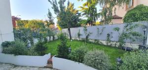 a backyard with a white fence and a garden at Superbe logement au style Londonien Avec Cinema Ideal pour des grandes familles et professionnels in Drancy