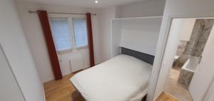 a small bedroom with a bed and a mirror at Superbe logement au style Londonien Avec Cinema Ideal pour des grandes familles et professionnels in Drancy