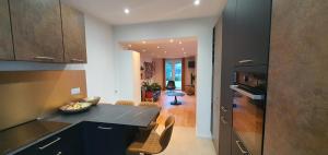 a kitchen with black cabinets and a counter top at Superbe logement au style Londonien Avec Cinema Ideal pour des grandes familles et professionnels in Drancy