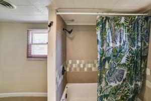 a bathroom with a bath tub with a shower curtain at Walk to River Oacoma Home with Dog-Friendly Yard! in Oacoma +31 photos