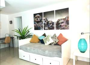 ein Zimmer mit einem Bett mit bunten Kissen darauf in der Unterkunft GroveO1 10 min from the beach in Miami