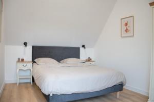 Schlafzimmer mit einem Bett und einem Beistelltisch in der Unterkunft Le Perrées cottage Peace and Tranquility in Juaye-Mondaye