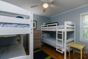 a bedroom with two bunk beds and a ceiling fan at Miss Irene in Edisto Island